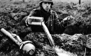 A German soldier, with a Panzerfaust beside him, bails out his foxhole